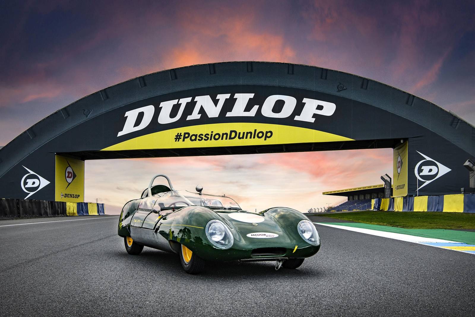Lotus Eleven verte sous la passerelle Dunlop du circuit du Mans